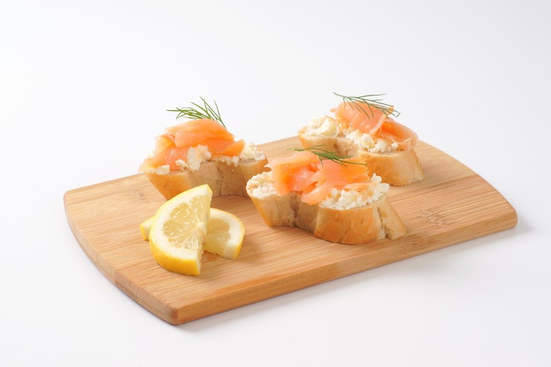 Bread based smoked salmon canapes on wooden cutting board,Image: 301052170, License: Rights-managed, Restrictions: , Model Release: no