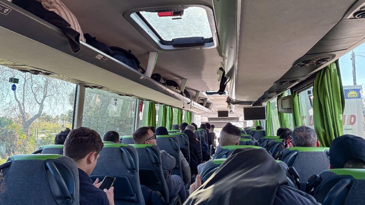 Mai mulți bărbați stau într-un autocar