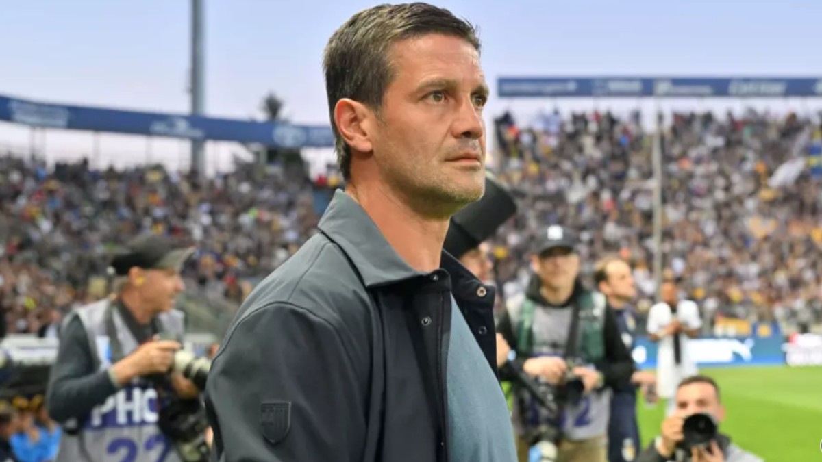 Cristi Chivu pe terenul de fotbal, îmbrăcat în tricou albastru și jachetă gri