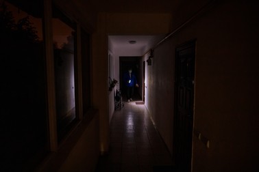 Un locatar al unui bloc din Sectorul 4 al Capitalei, care nu are curent de mai multe luni, umblă cu lanterna după lăsarea întunericului.