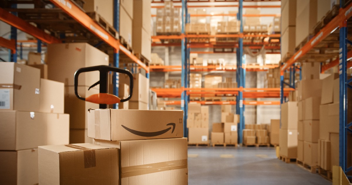 Un depozit în care se află pachete care conțin logo-ul Amazon