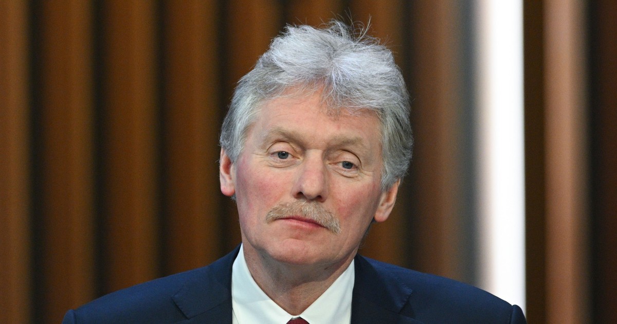 Dmitri Peskov poartă o cravată roșie, o cămașă albă, peste care a asortat un sacou albastru închis