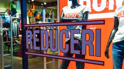 Discount (reduceri), sale signs, red poster offer, mock up advertise display frame over clothes in shopping mall or department store for show promotion product at AFI Cotroceni Mall from Bucharest, Romania, 2020