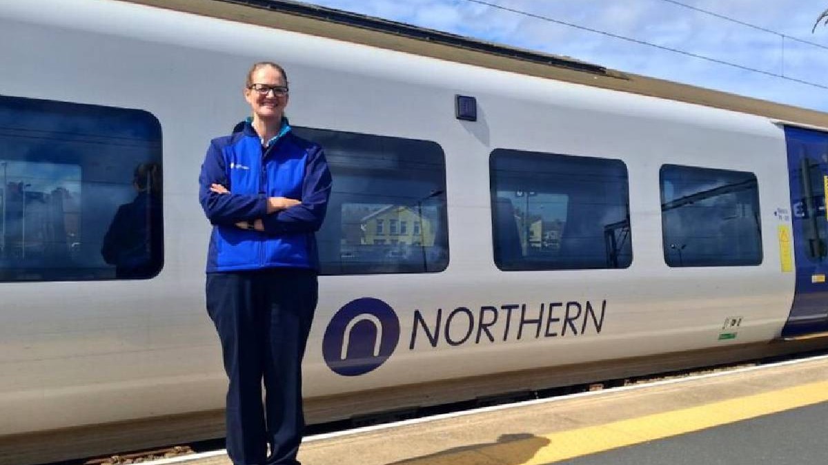 Alex Worsick , fosta jurnalista BBC, pe peron in fata unui tren pe care scrie NORTHERN