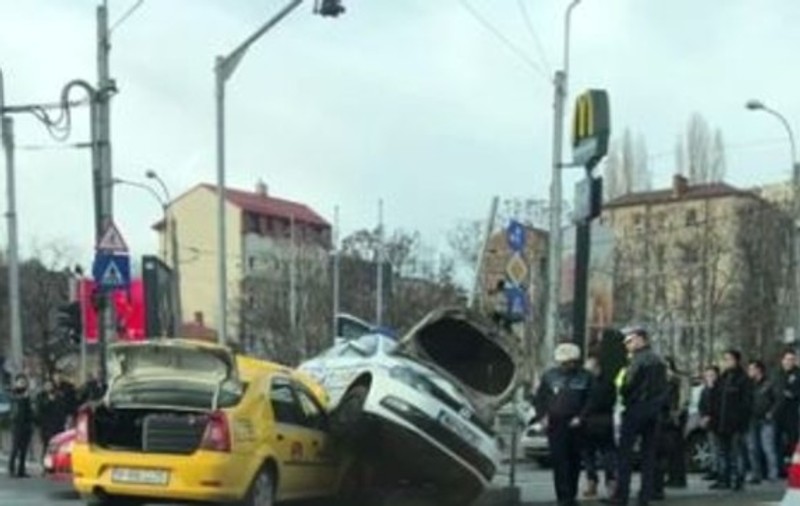 Accident spectaculos în Capitală. Mașină de poliție cocoțată peste un taxi