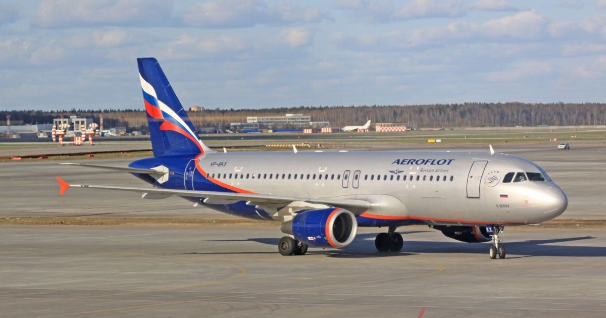 Un avion Aeroflot este la sol pe aeroportul Șeremetievo din Moscova, Rusia, iar în depărtare se vede o pădure