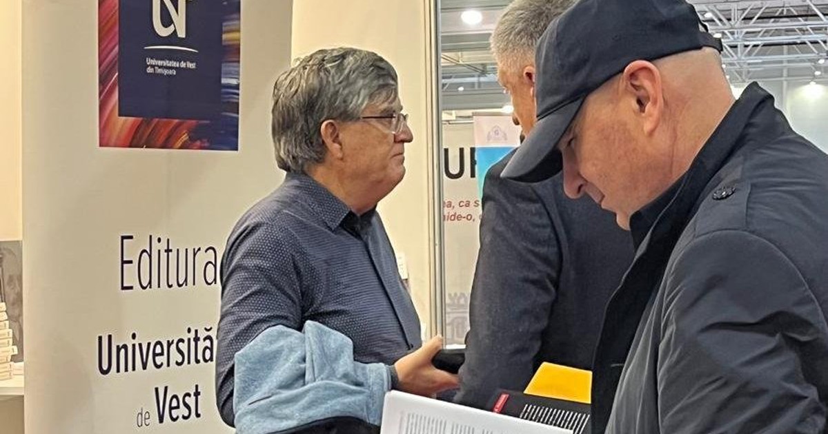 Ilie Bolojan cu o șapcă pe cap se uită pe o carte.