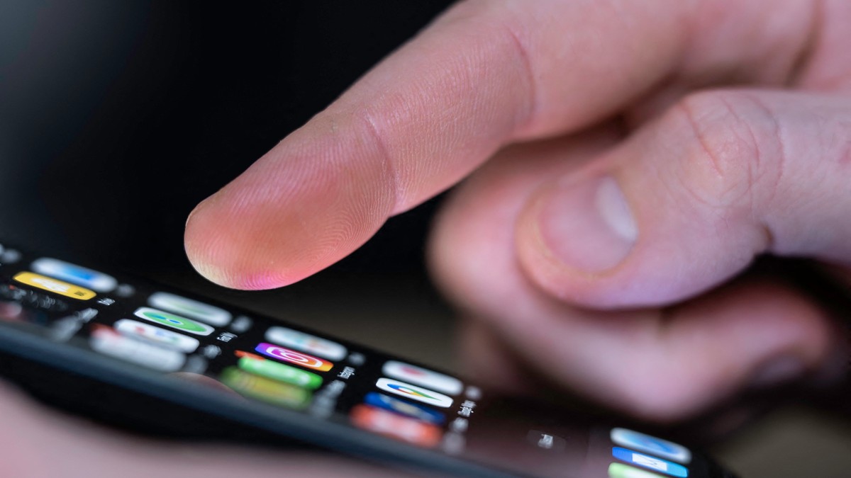 O persoană butonează pe Iphone-ul său