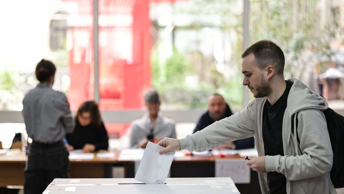 O persoană introduce buletinul de vot în urnă la o secție din București, în turul 2 al alegerilor prezidențiale 2025