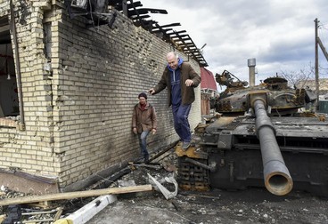 epa09874217 Local residents explore a destroyed Russian tank in the small city Hostomel in Kyiv (Kiev) area, Ukraine, 06 April 2022. Some cities and villages had recently been recaptured by the Ukrainian army from Russian forces and now people try to restore normal life there. On 24 February, Russian troops had entered Ukrainian territory in what the Russian president declared a 'special military operation', resulting in fighting and destruction in the country, a huge flow of refugees, and multiple sanctions against Russia. EPA-EFE/OLEG PETRASYUK