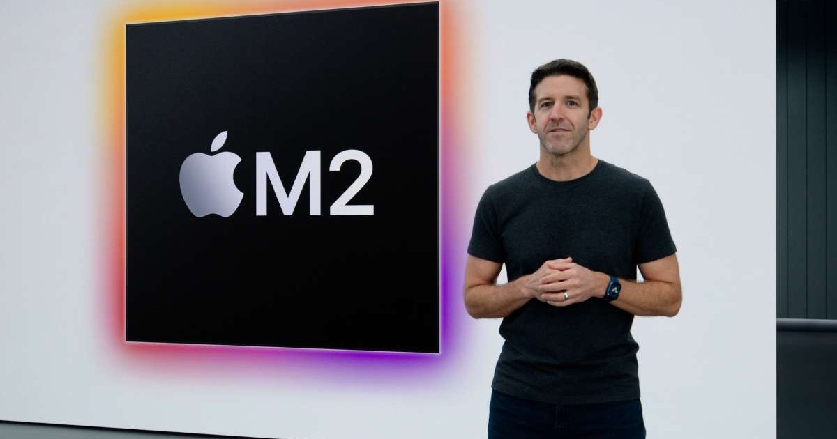 John Ternus, viitorul CEO al Apple, lângă un logo mărit „M2”, cu trimitere la procesoarele produse de companie.
