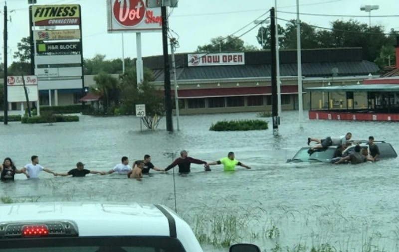 Clipe dramatice în orașul Houston, aflat sub ape. Oamenii au format un lanț uman pentru a salva un om blocat în mașina sa | VIDEO