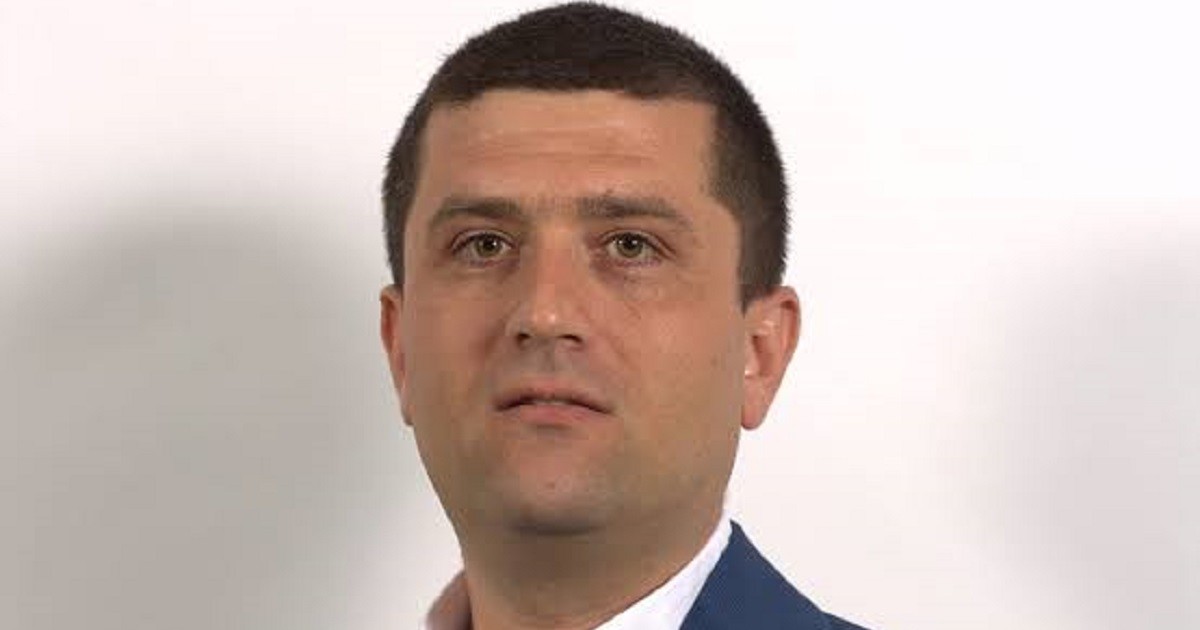 Radu Miruță, îmbracat într-un costum albastru inchis și o cămașă alba