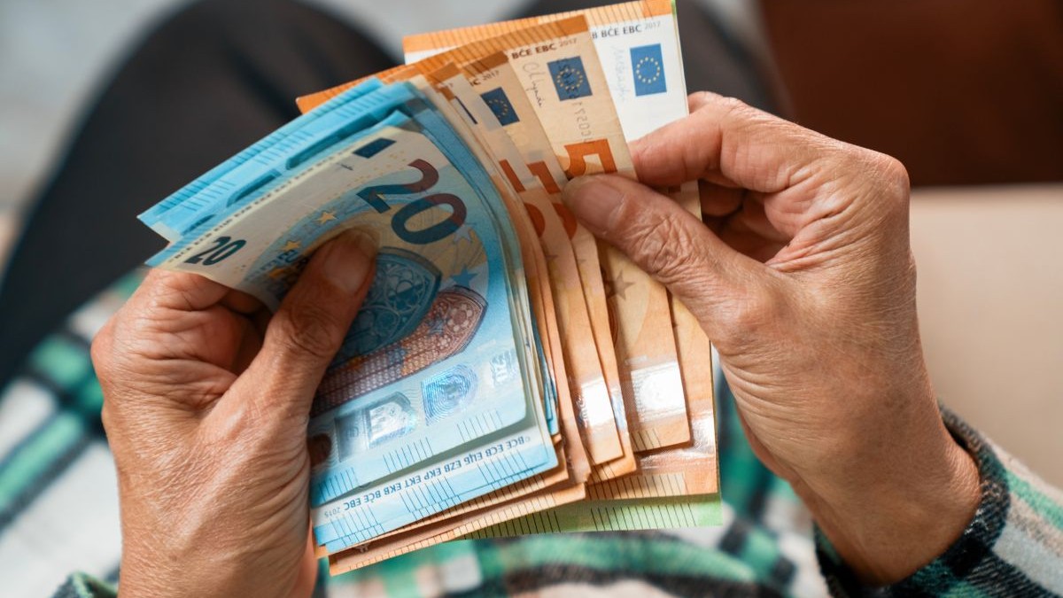 Bancnote de 50 și 20 de euro, numărate de mâinile unui bărbat, în prim-plan
