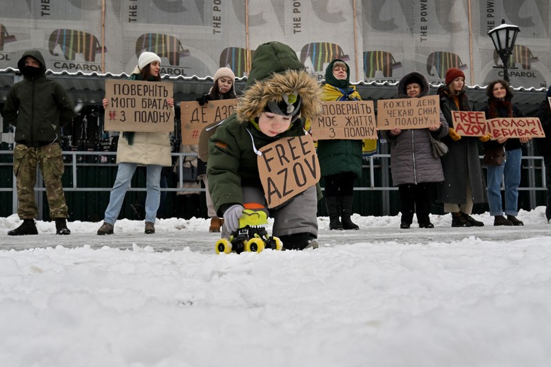 Copii, rude și camarazi de arme ai prizonierilor de război Ucraineni din Brigada Azov țin pancarte la mitingul din Kiev din 21 ianuarie 2024, cerând schimbul lor cu prizonieri ruși, pe fondul invaziei ruse în Ucraina. Foto: AFP
