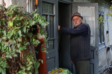 Gheorghe Hogaş și casa părintească pe care tatăl lui a ridicat-o, atunci când el avea doar 10 ani. Sursa foto: Vlad Chirea