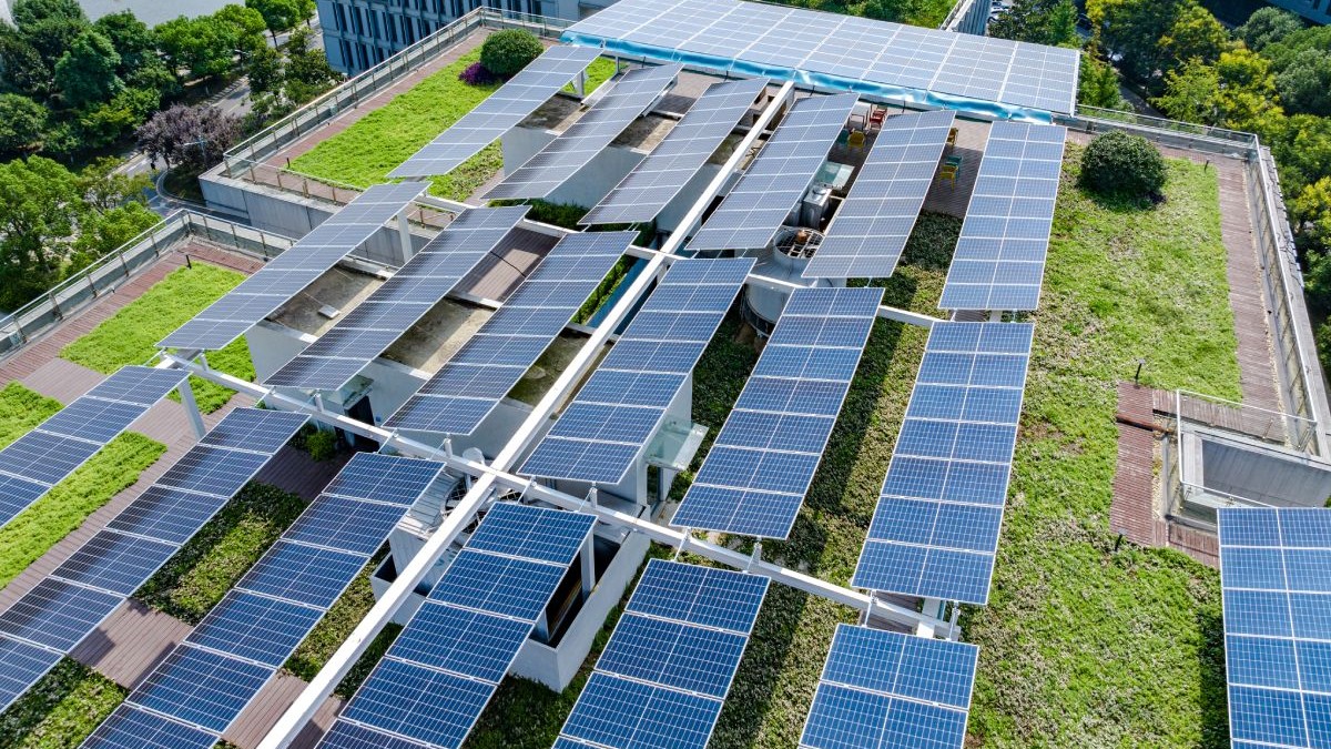 Spații verzi și panouri fotovoltaice pe acoperișul unei clădiri, imagine aeriană cu acoperișul