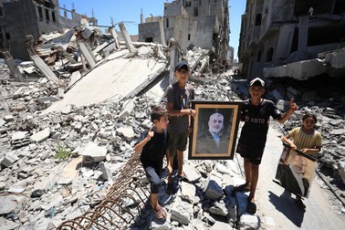 GAZA CITY, GAZA - JULY 31: Palestinians carry the portrait of Hamas political bureau chief Ismail Haniyeh, who was assassinated, as they stand on the debris of destroyed building, belonged to Ismail Haniyeh, following the Israeli attack in Al-Shati refugee camp of Gaza City, Gaza on July 31, 2024. Hamas announced early that Haniyeh was killed in an Israeli airstrike on his residence in the Iranian capital Tehran. Dawoud Abo Alkas / Anadolu/ABACAPRESS.COM,Image: 894554803, License: Rights-managed, Restrictions: , Model Release: no