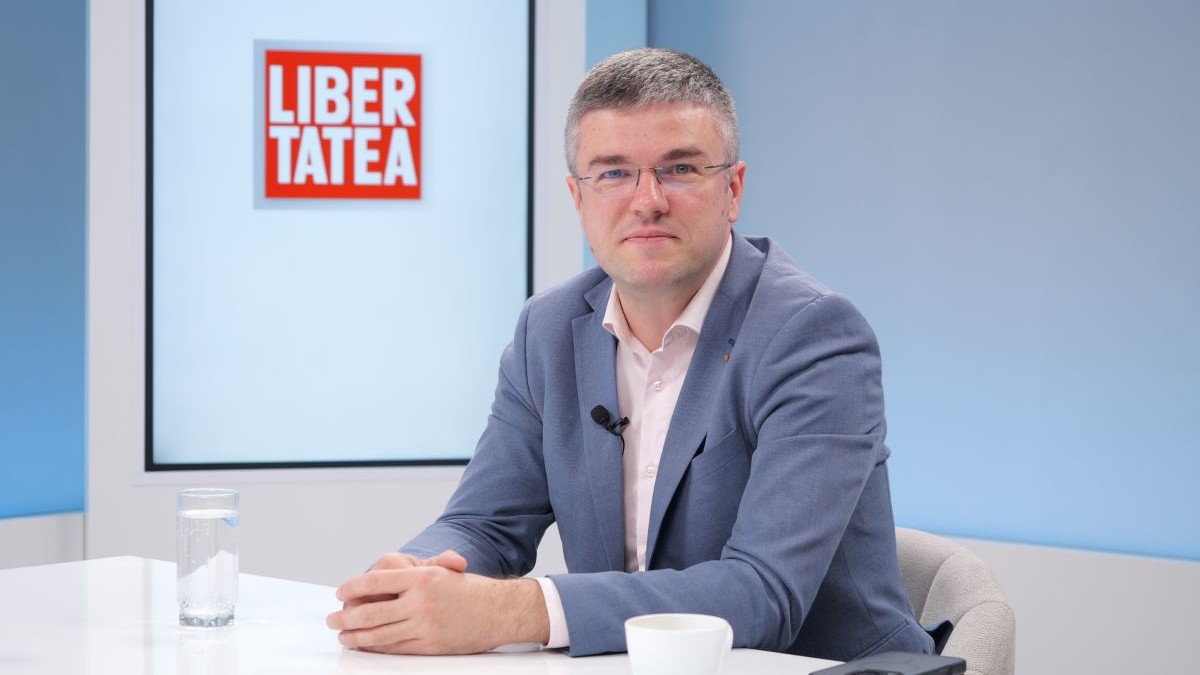 Irineu Darău, îmbrăcat cu costum de culoare albastră și cămașă albă, pe fundal sigla Libertatea, la Interviurile Libertatea, pe 17 august 2026