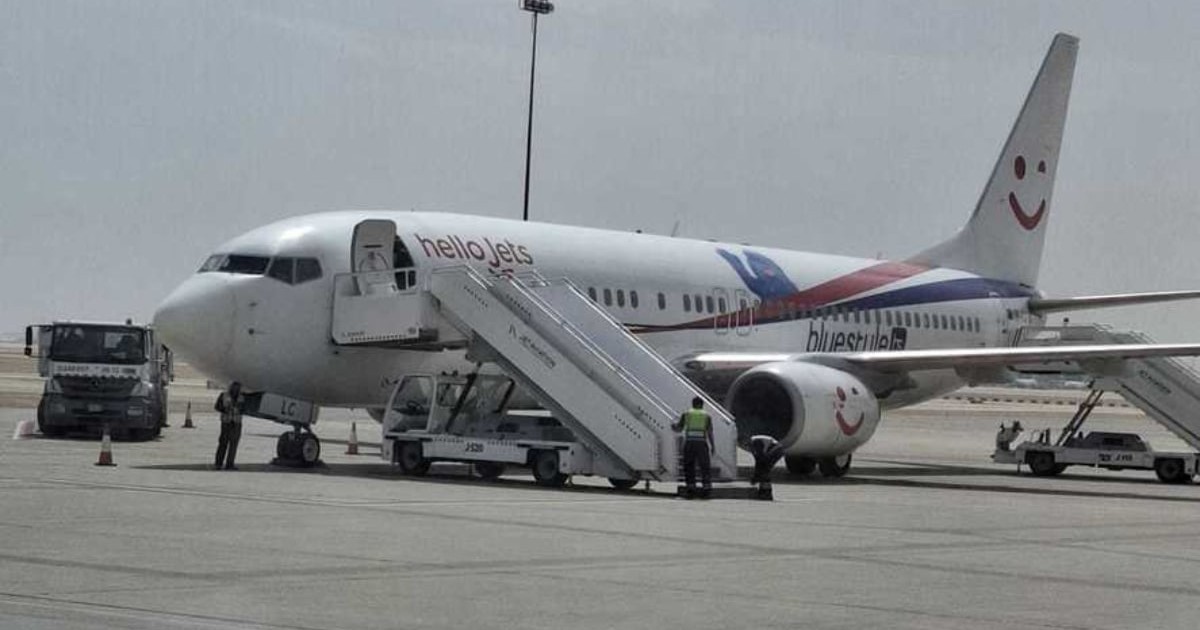 Un avion care stă pe pista unui aeroport și așteaptă turiștii la îmbarcare
