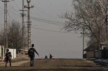 Copii mergând acasă de la școală, pe ulițele unui sat