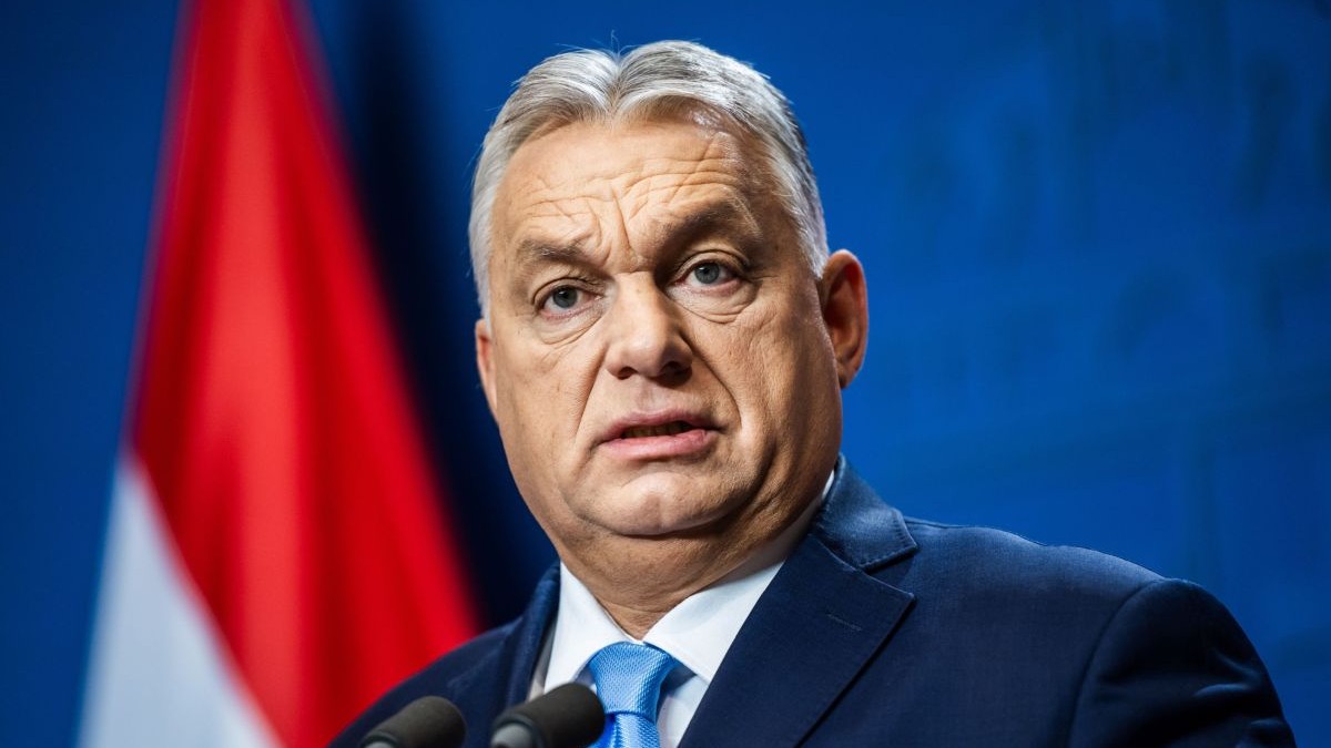 Viktor Orban vorbește în fața unui microfon, având în fundal steagul Ungariei, 21 decembrie 2024