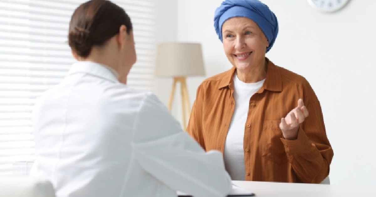 O femeie cu turban in cap sta in cabinetul medical si explica medicului. mielom multiplu. Traseul pacientului in Romania