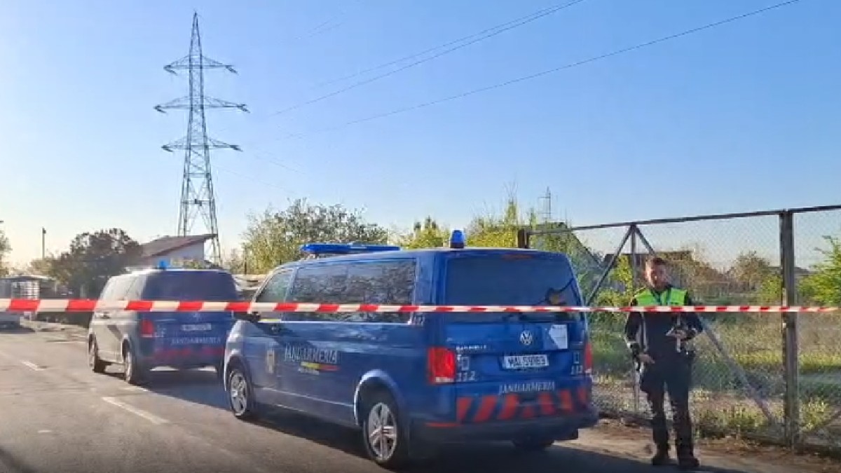 Mai multe mașini de Jandarmerie albastre, un polițist care păzește zona din Galați în care au căzut fragmente de dronă.