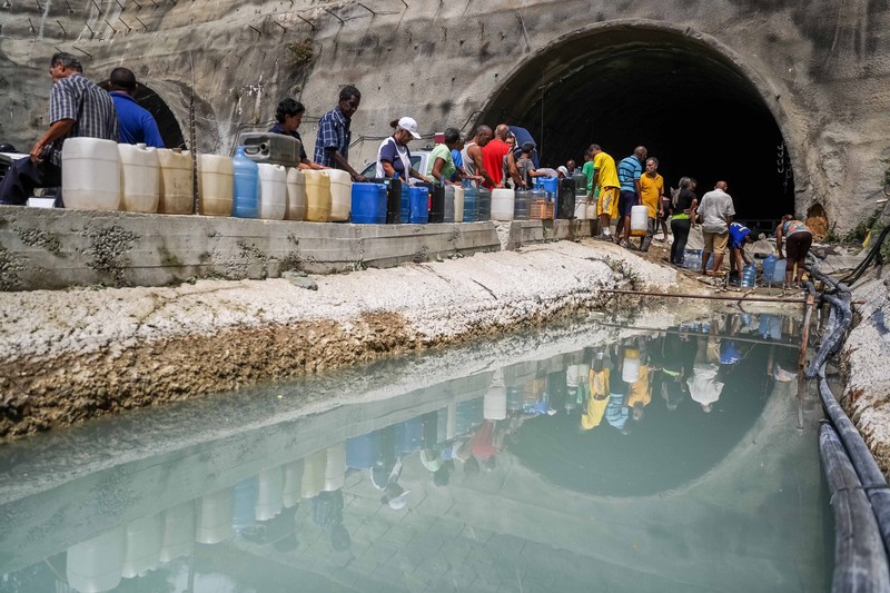 Oamenii colectează apă într-un șantier de construcție abandonat în cartierul Mecedores, în Caracas, Venezuela, 01 aprilie 2019. Foto: EPA-EFE / Miguel Gutiérrez