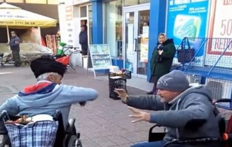 Scandal între doi cerșetori în scaune cu rotile în Piatra Neamț. Oamenii s-au bătut, iar martorii i-au filmat pentru amuzament | VIDEO