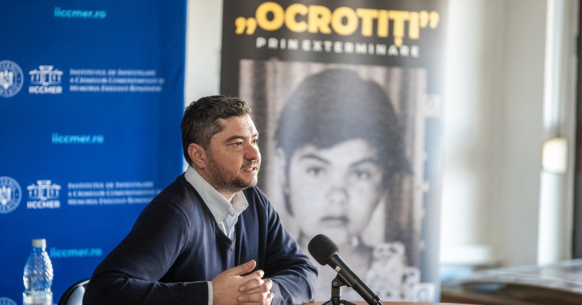 Dr. Florin Soare, istoricul care a semnalat ororile petrecute în căminul pentru copii irecuperabili de la Moreni-Țuicani. Imbracat in pulovar bleumarin si camasa alba, sta la un boriu si vorbeste la un microfon. In spate se vede un poster cu un copil
