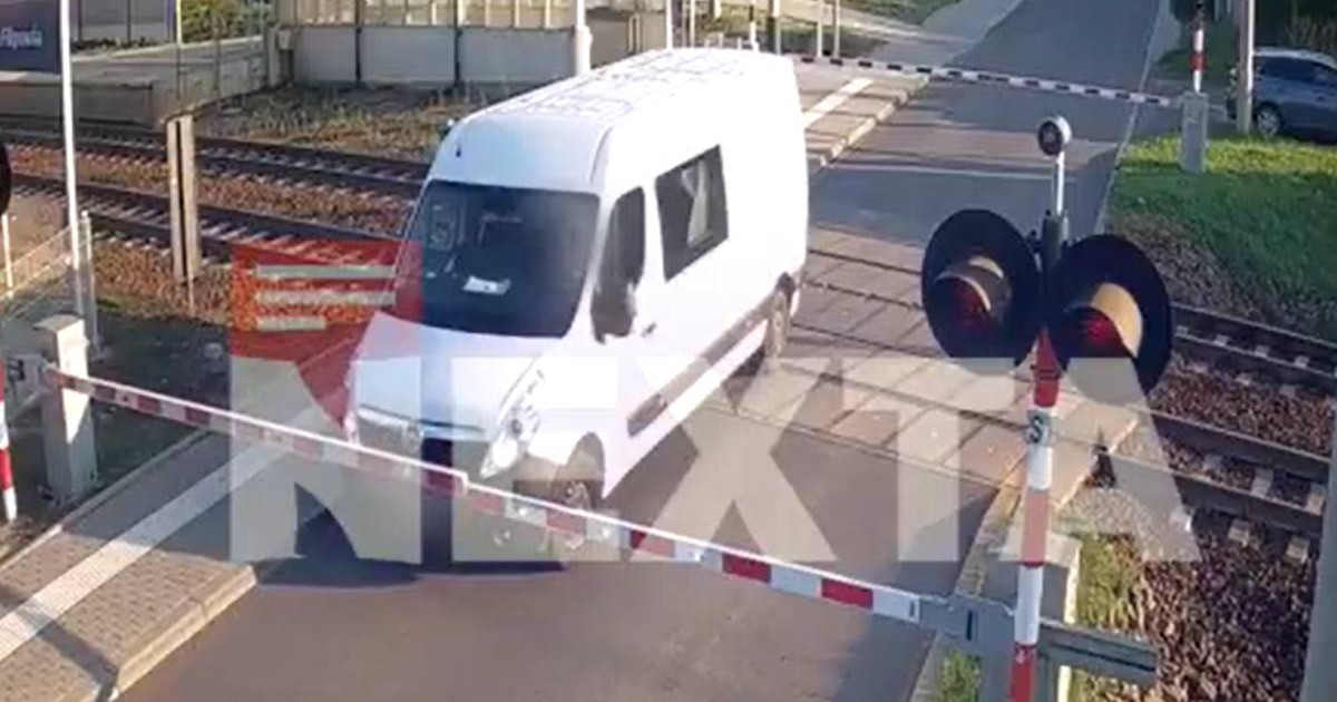 Imagine cu duba alba Opel rămasă blocată între bariere, în Polonia. Imagine surprinsă înainte ca vehiculul să fie lovit de tren