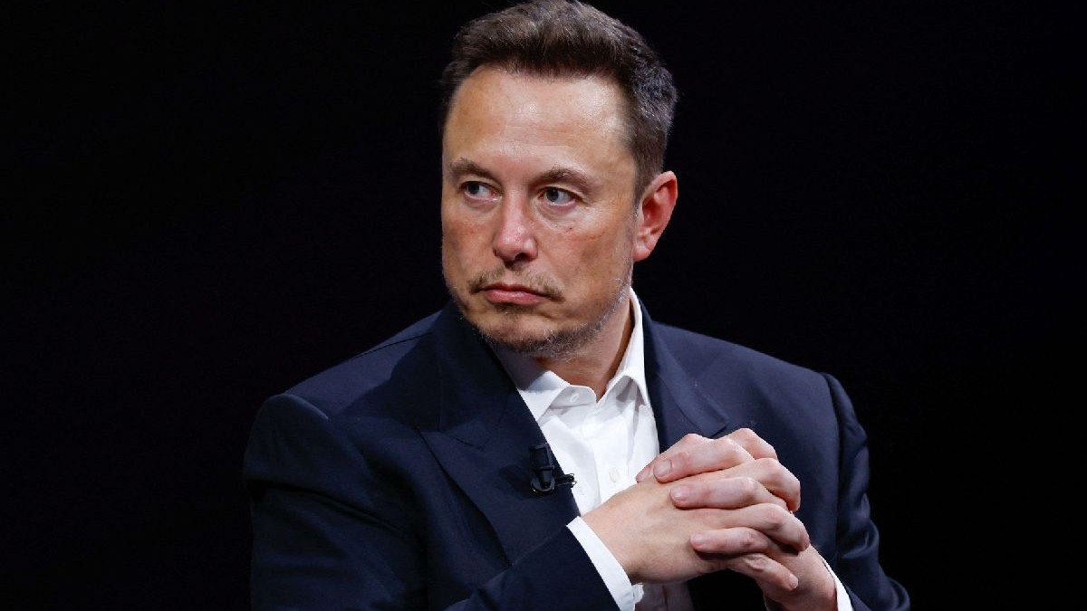 Fotografie cu Elon Musk, îmbrăcat într-un costum negru și cămașă albă