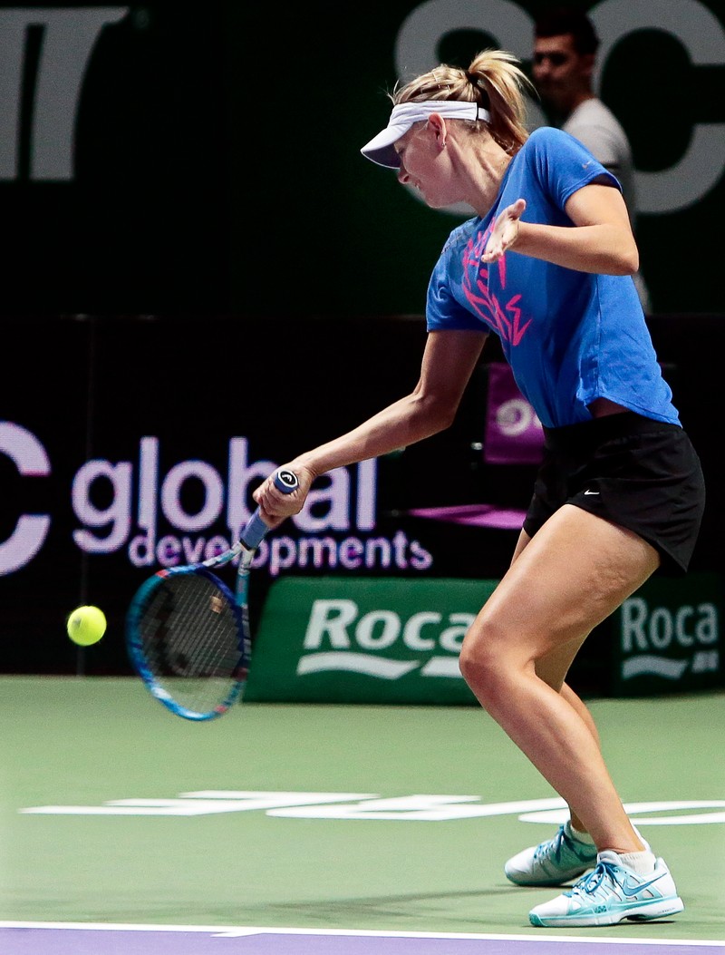 epa04998090 Maria Sharapova of Russia performs during a training session ahead of her round robin match against Simona Halep of Romania at the BNP Paribas WTA Finals 2015 tennis tournament in Singapore, 27 October 2015. EPA/WALLACE WOON