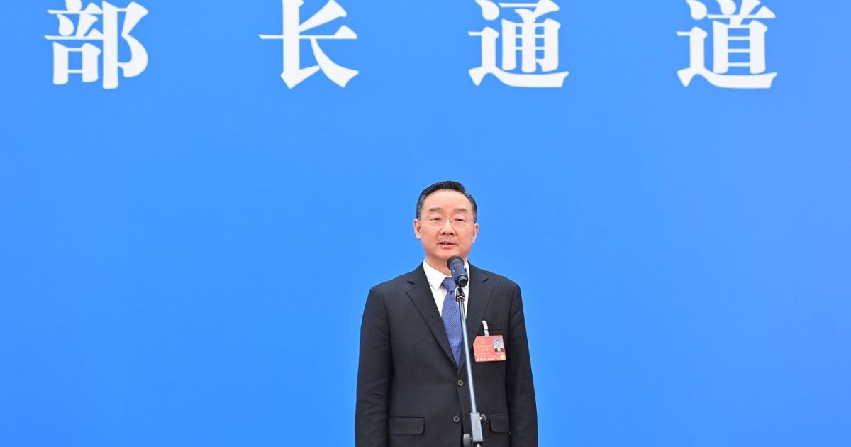 Tang Renjian vorbește la microfon în timpul unei conferințe de presă, martie 2022