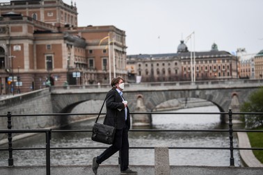 Un bărbat cu mască, în fața Operei Regale din Stockholm Foto:Epa
