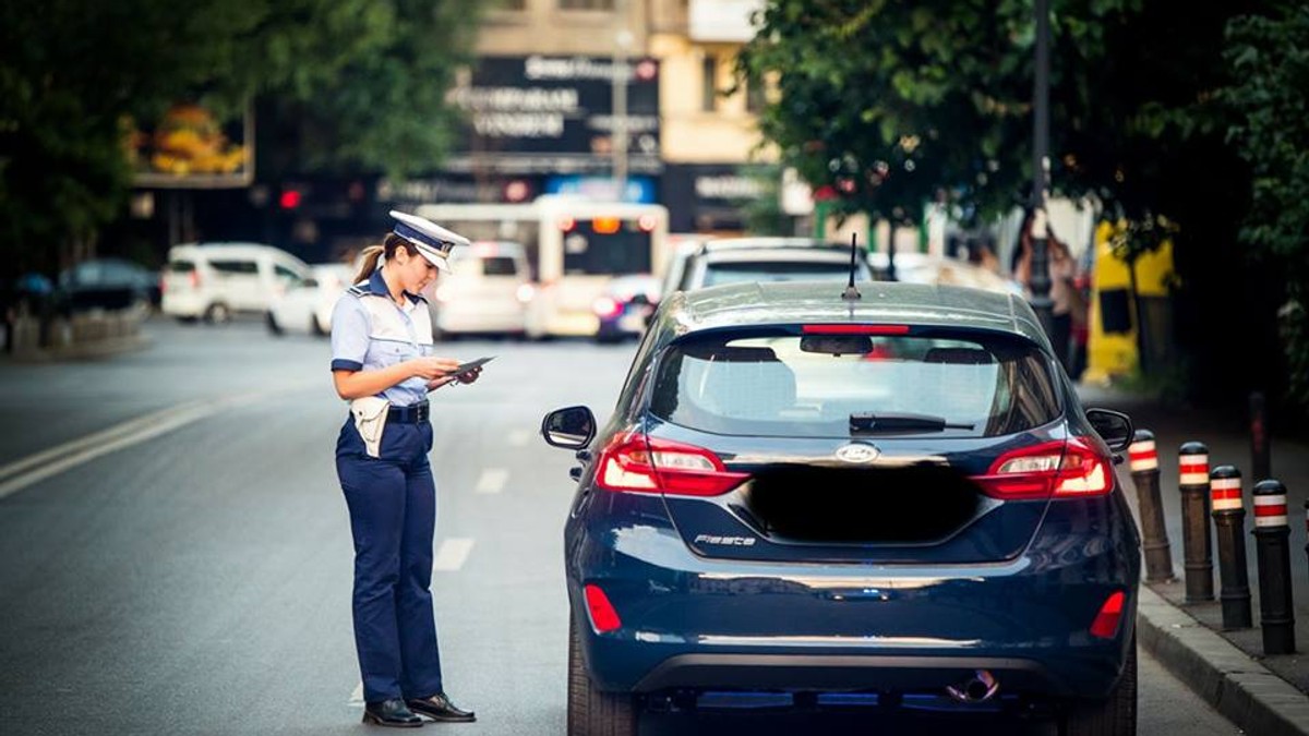 O femeie din Dolj a vrut să mituiască polițiștii. O polițiștă rutieră controlează șoferul unei mașini
