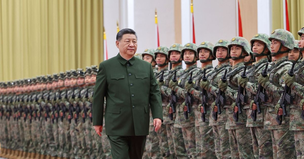 Îmbrăcat cu o tunică tradițională , Xi Jinping trece pe lângă mai mulți militari chinezi aliniați și îmbrăcați de luptă, cu arme în mâini și căști pe cap
