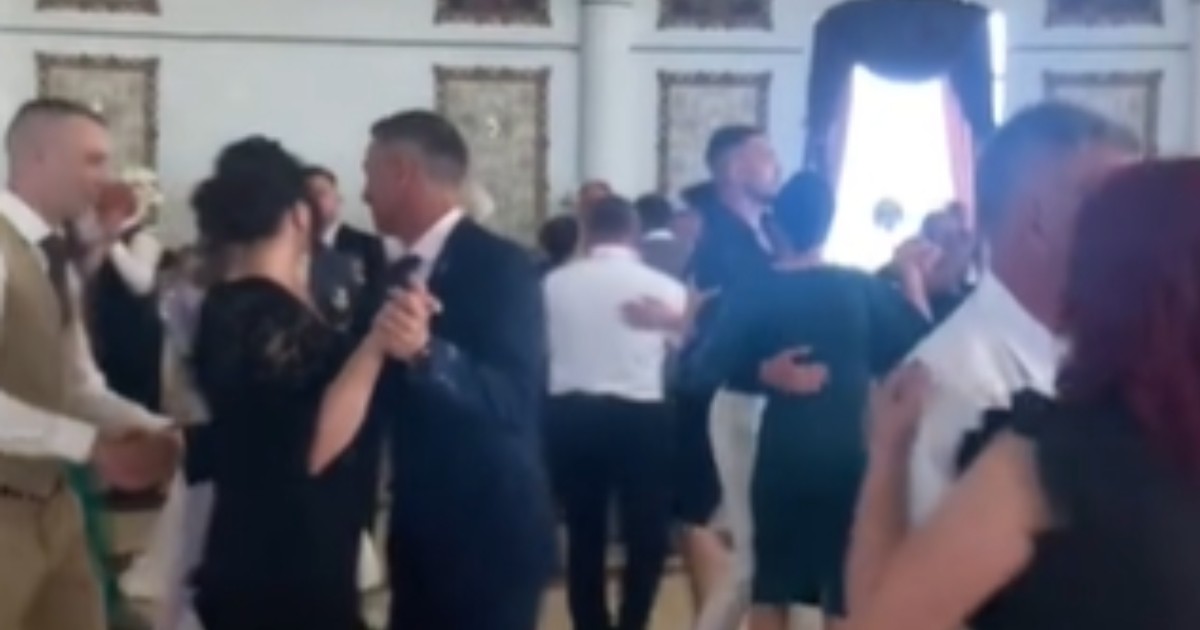Oameni îmbrăcați elegant care se află la o nuntă și dansează