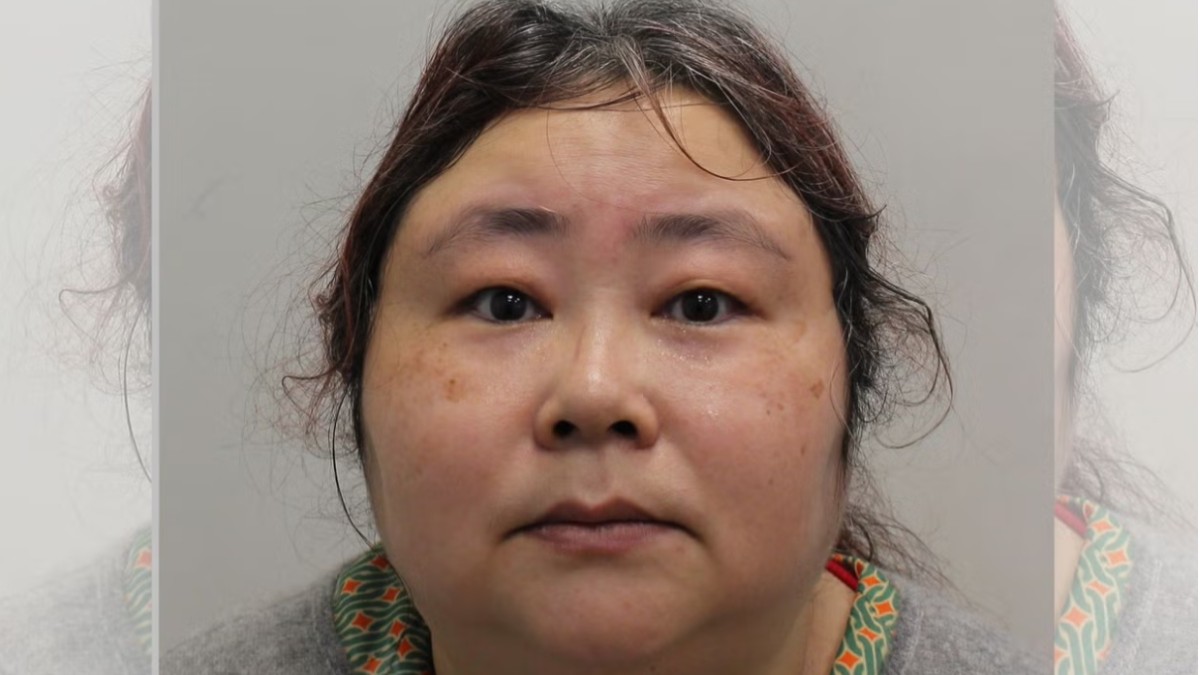 Un portret frontal al lui Zhimin Qian, cu părul închis la culoare, având o expresie serioasă. Lumina este puternică, punând în evidență detaliile feței.