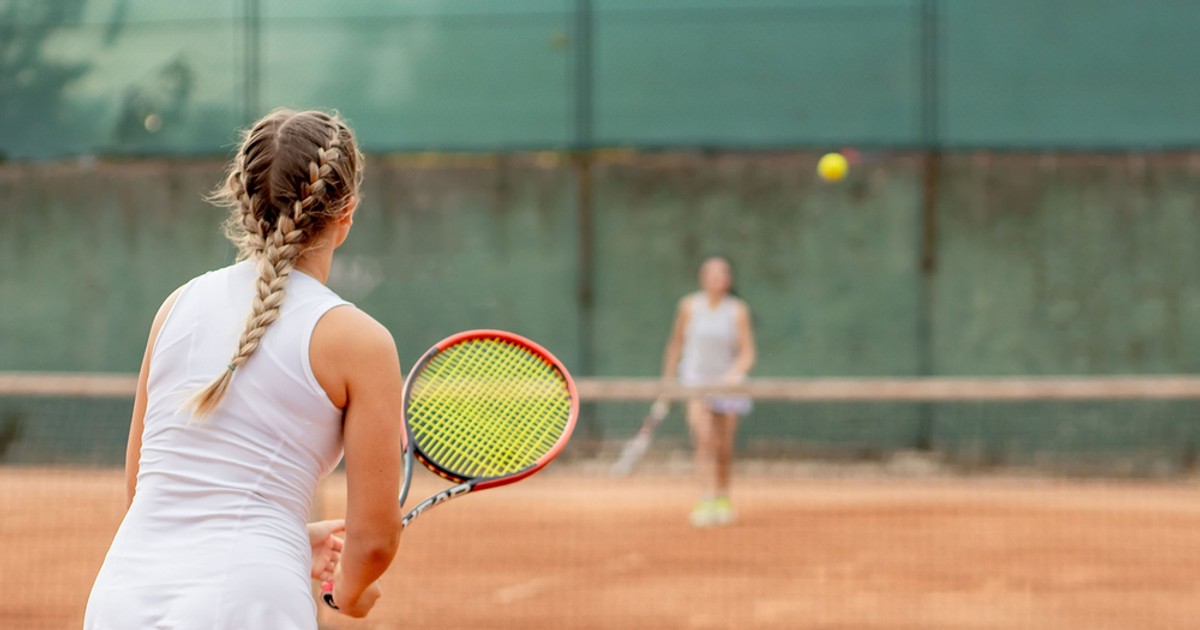 Unde poţi juca tenis de câmp în Bucureşti în 2022 - Imagie cu două fetiţe care joacă tenis pe un teren de zgură.