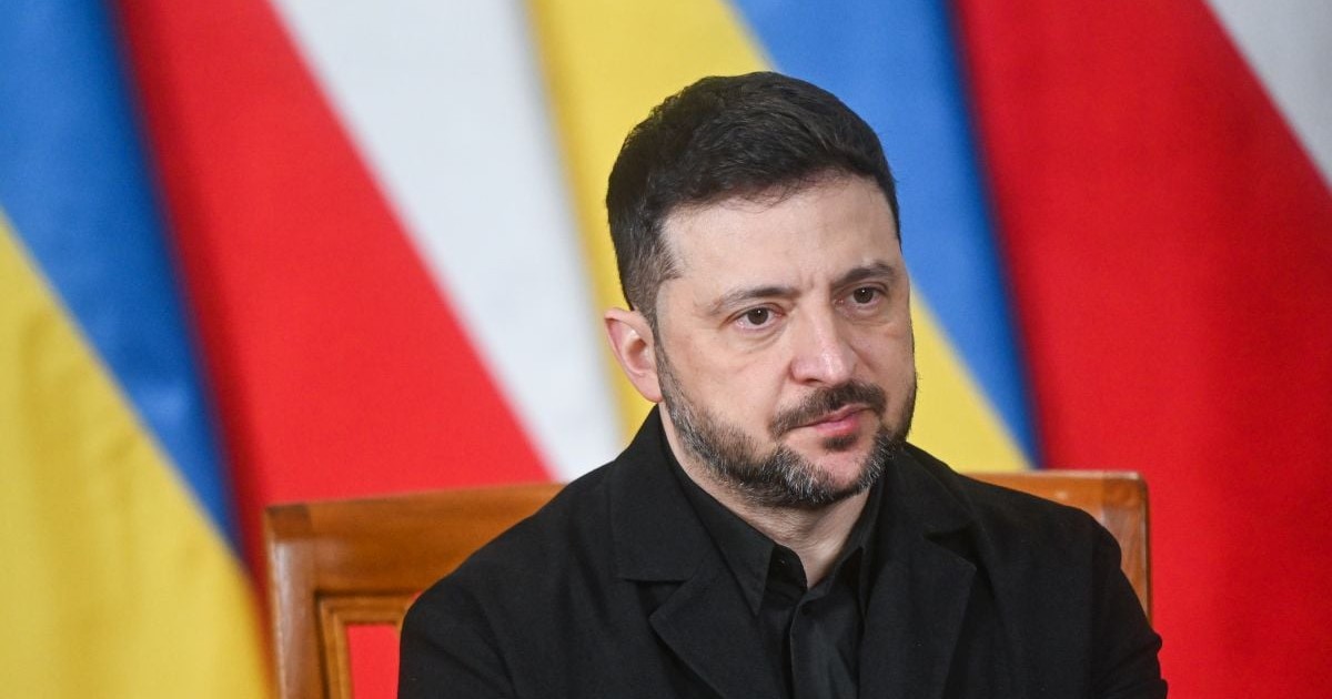 Volodimir Zelenski, având pe fundal steagurile Poloniei și Ucrainei, vorește în timpul unei conferințe de presă la Varșovia, 19 decembrie 2025