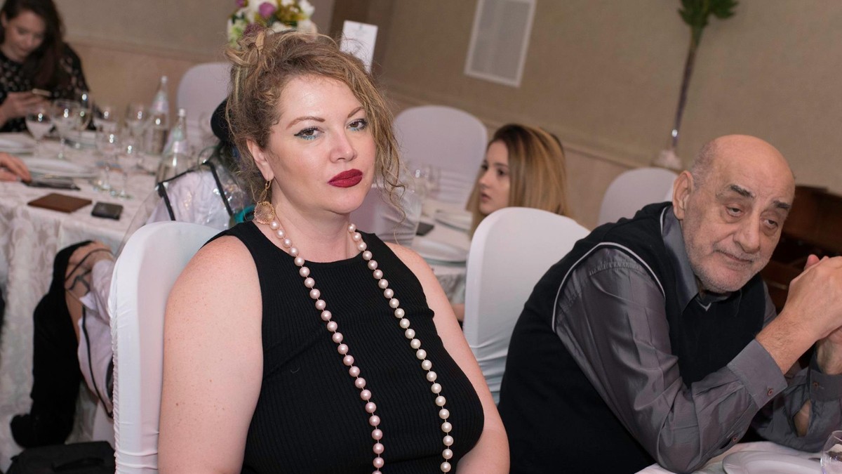 Oana si Viorel Lis. Vedeta, într-o rochie neagră sexy, stă la masa, alături de soțul ei