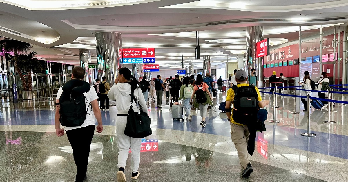 Turiști pe aeroportul din Diubai, în timp ce merg spre porțile de îmbarcare
