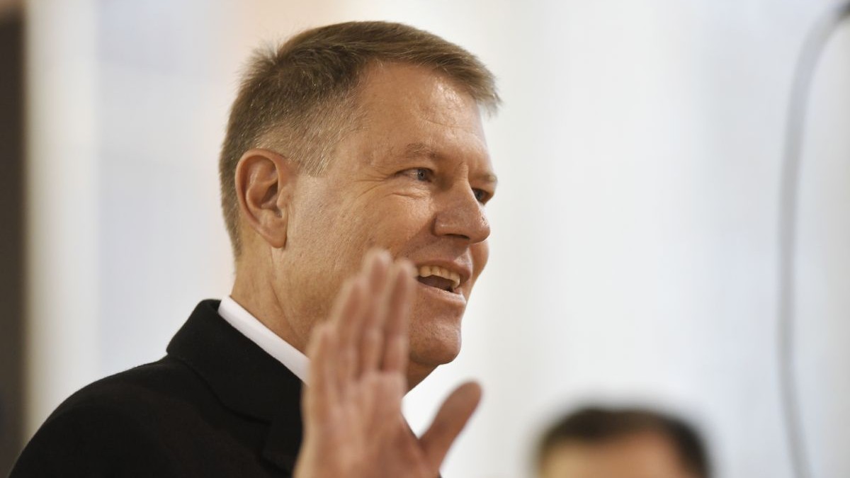 Klaus Iohannis, președintele României, în prim plan, în timp ce face cu mâna, după ce a votat