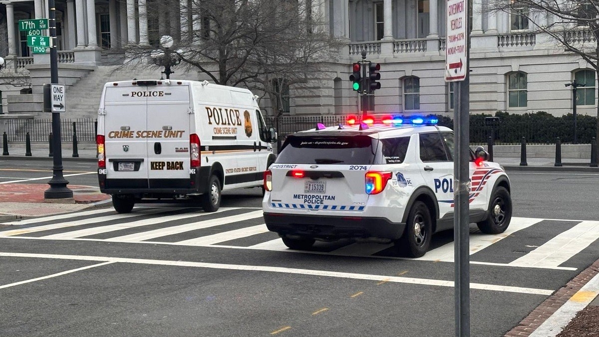 Mașini de poliție, una dintre ele cu girofarul aprins, pe un belevard închis circulației din Washington DC