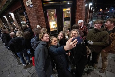 Oamenii își fac un selfie în fața unui bar din Malmoe, Suedia, în noaptea de 9 februarie când țara a renunțat la multe din restricții. Foto: Profimedia