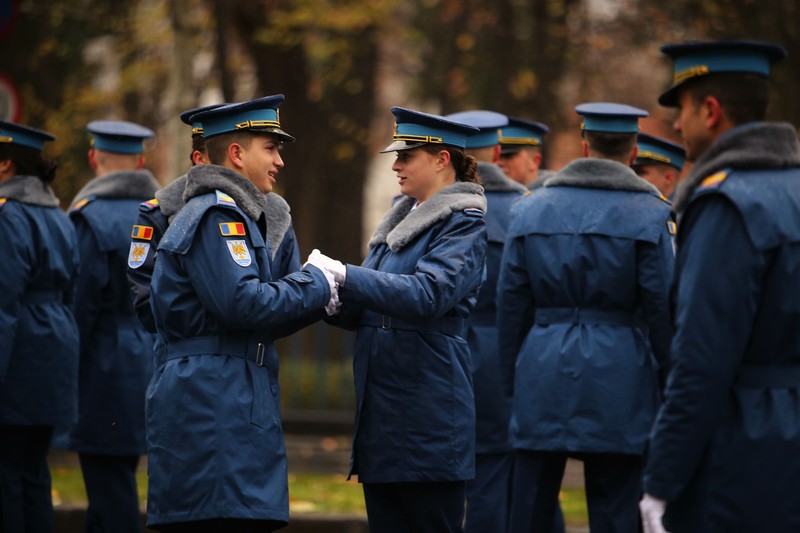 Participanți la defilare își încălzesc mâinile înainte să înceapă parada