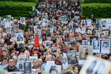 8 mai 2019 - Oamenii merg către Monumentul Soldatului Necunoscut din Kiev, ținând portretele soldaților care au murit în cel de-Al Doilea Război Mondial. Foto: Profimedia