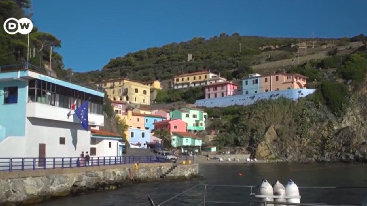 Gorgona, Italia, insula colonie penitenciar. In imagine se vede un mic port si case tipic italiene pe un deal de pe insula